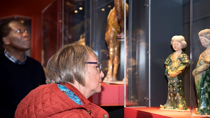 Lady looking at an object in a glass cabinet